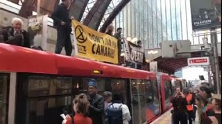 WHARF HLDGS LTD. WARFF Extinction Rebellion activists protest on top of train at Canary Wharf
