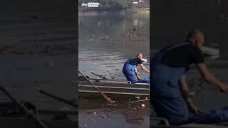 Volunteers clean up lake after deadly floods