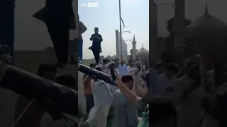 Crowd carries downed drone