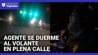 Graban a un agente que se quedó dormido al volante en plena calle